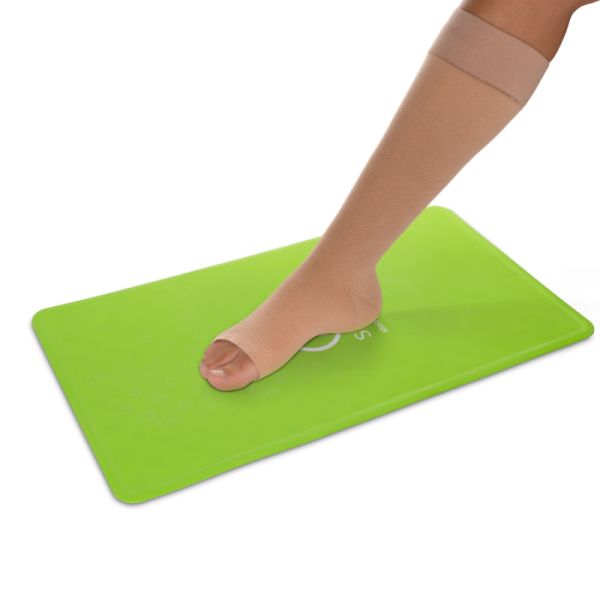 voet met elastische kous staat op groene Steve Mat anti-slip mat